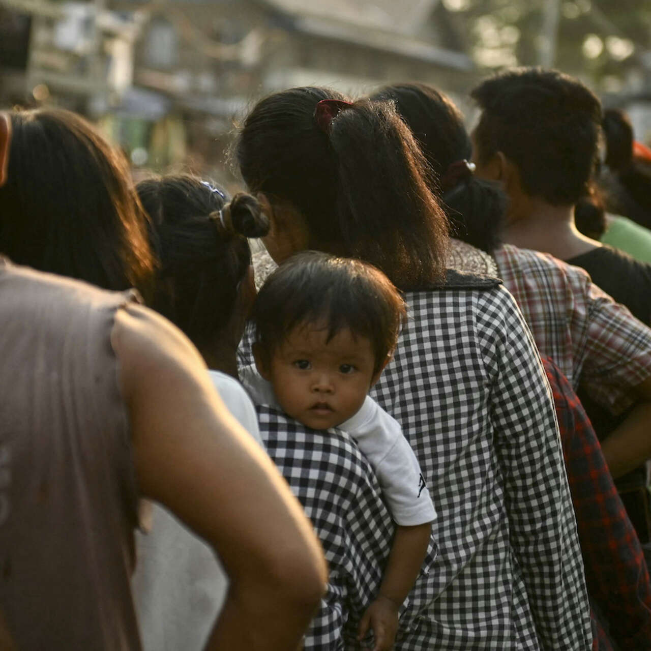 식량배급을 받기위해 늘어선 긴 줄에서 한 어린이가 바라보고 있습니다.