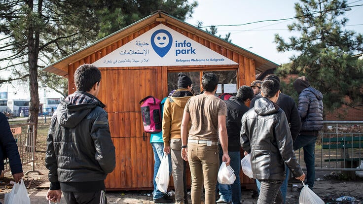 Refugees queue at the IRC's partners InfoParks information point.