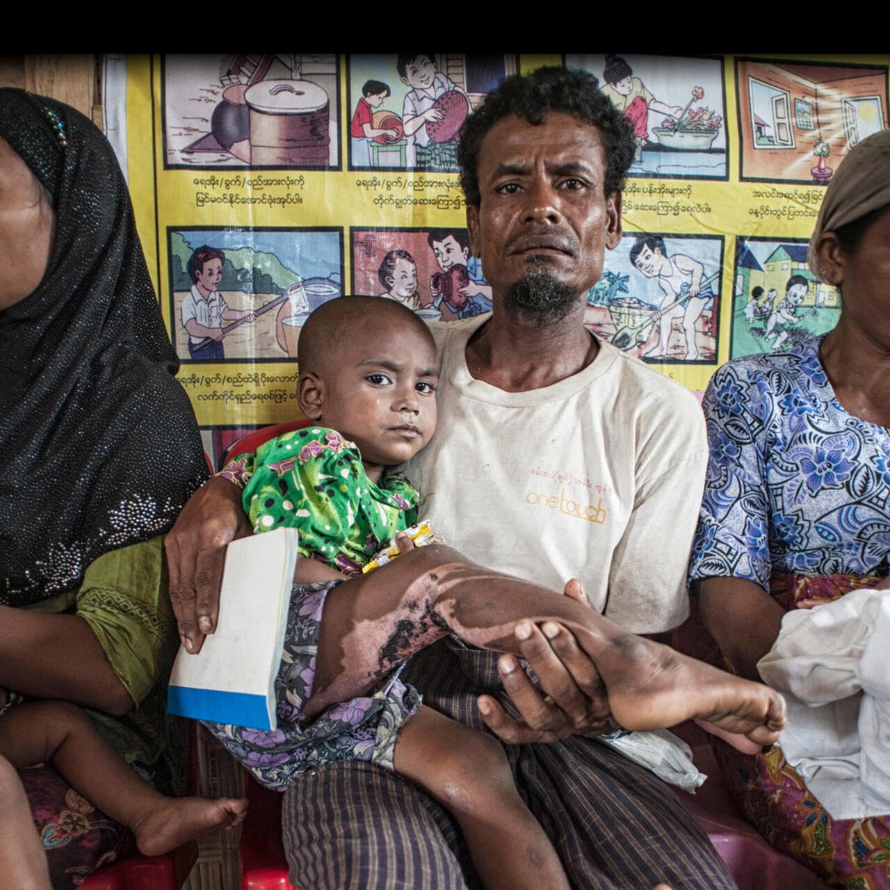 Eine Familie mit zwei Kleinkindern erhält im Flüchtlingslager Da Paing in Myanmar in einer von RESCUE unterstützten Klinik medizinische Versorgung.
