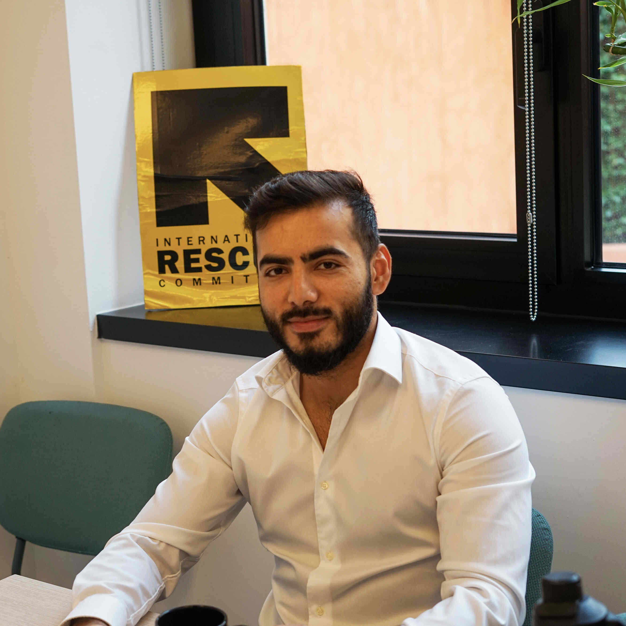 Ozair sitting in the IRC office in Milan, Italy