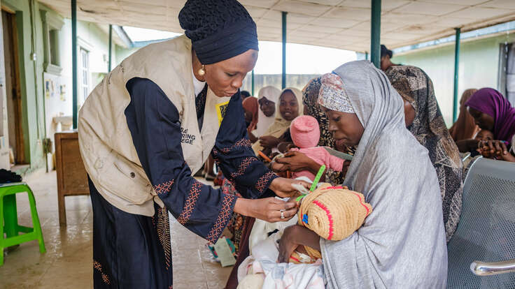 Mothers learn how to use the MUAC to check if their child is malnourished.