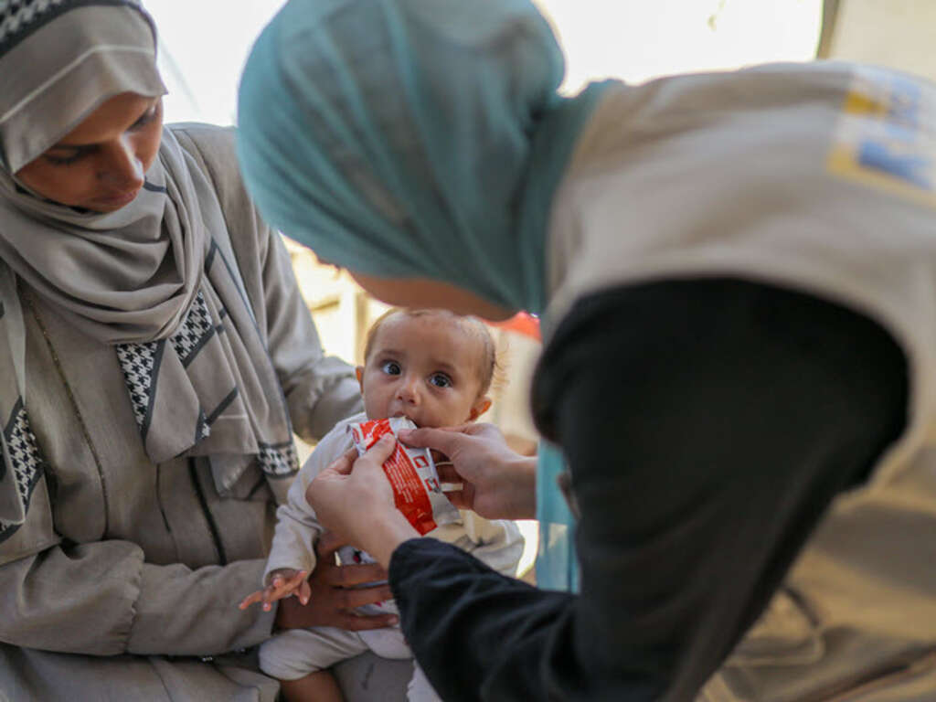 A child being fed by IRC volunteers in Shams Camp, Gaza, Palestine.