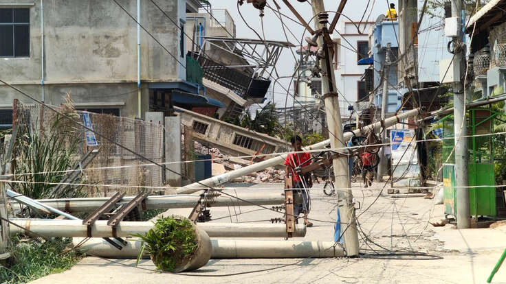 A man examines a downed power line caused by the earthquake in Myanmar.