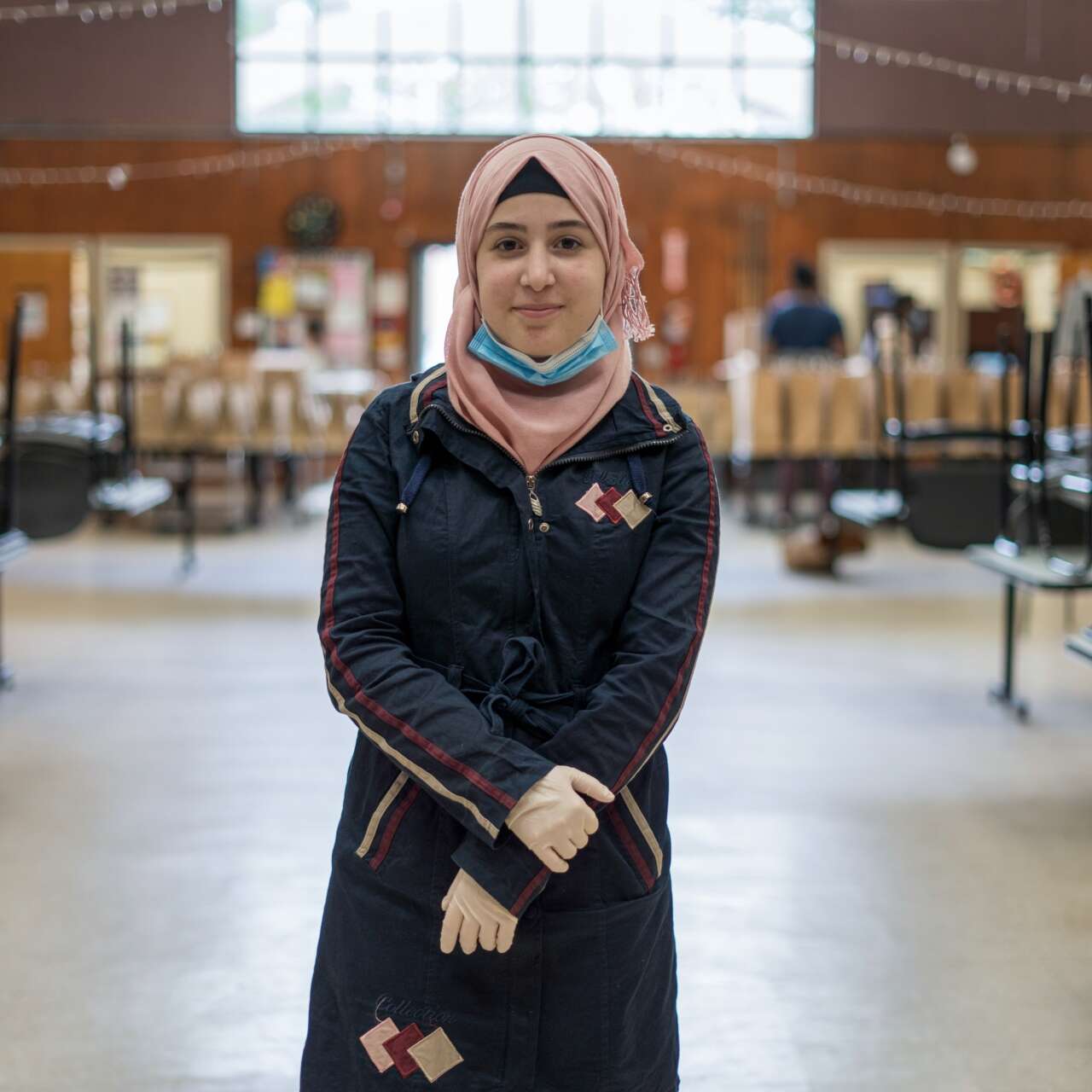 A woman stands, smiling, at the IRC office in Elizabeth, New Jersey.